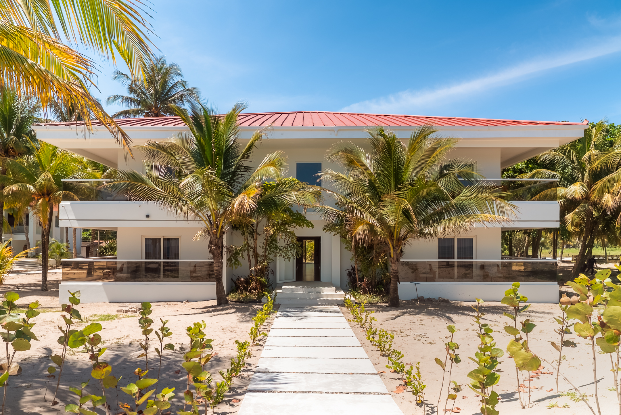 Edificio de Honduras Shores rodeado de palmeras frente a la playa