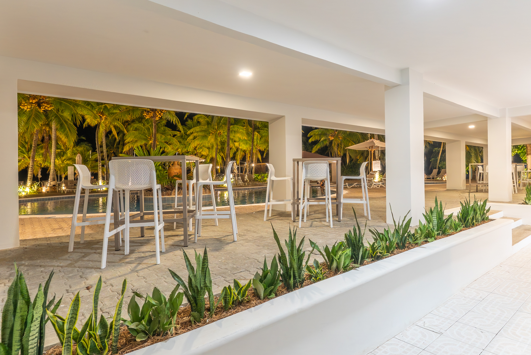 Área social del club por la noche junto a la piscina