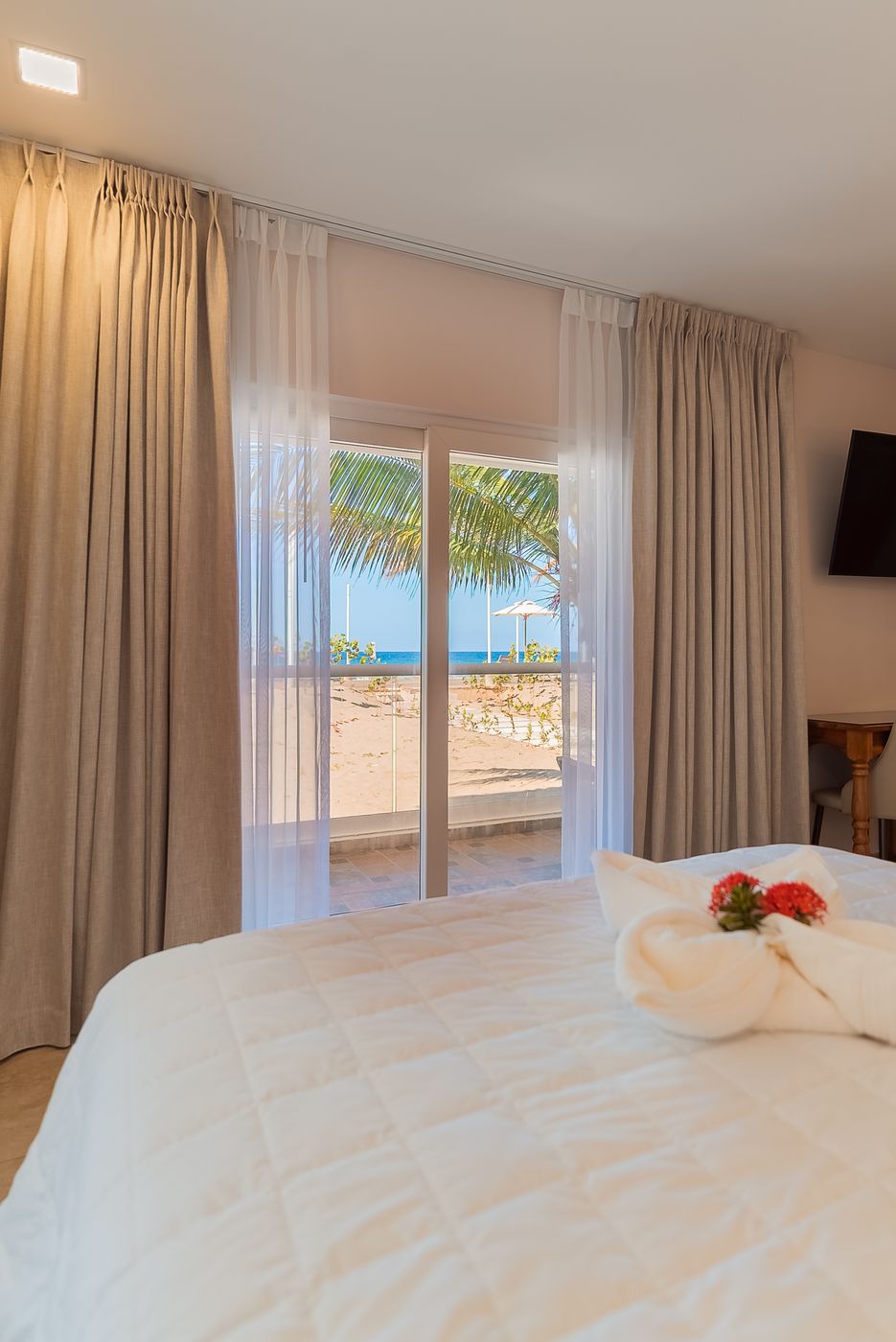 Habitación con cama y puerta abierta al balcón con vista al mar