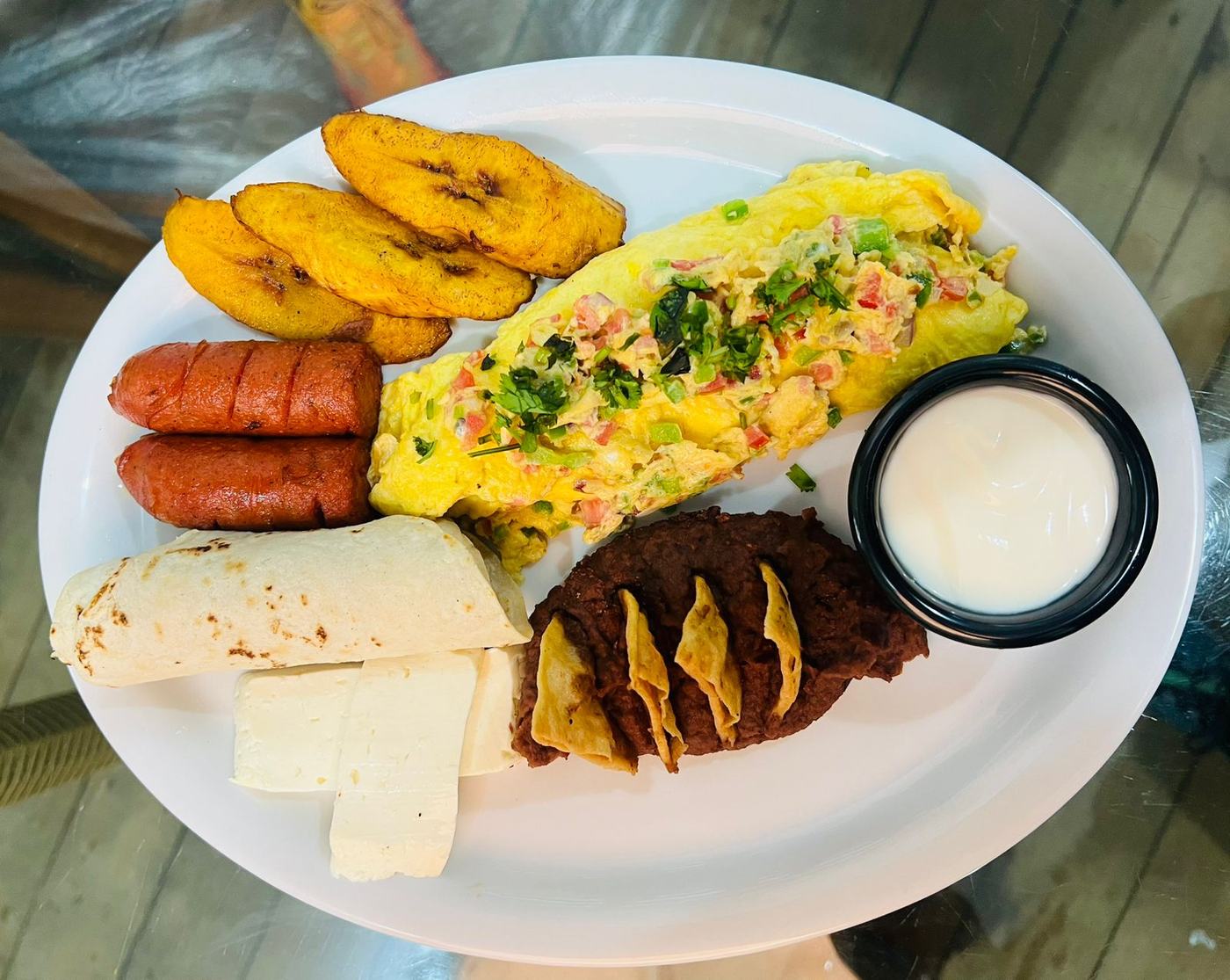 Desayuno típico hondureño con plátano, frijoles y queso